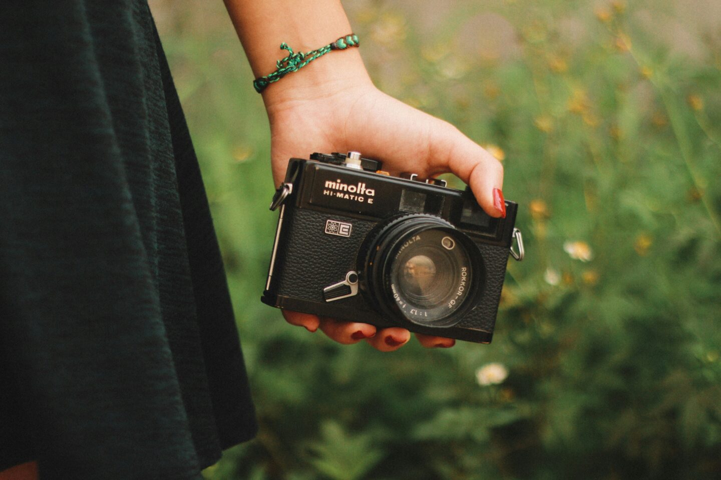 A hand holding a camera in a natural environment