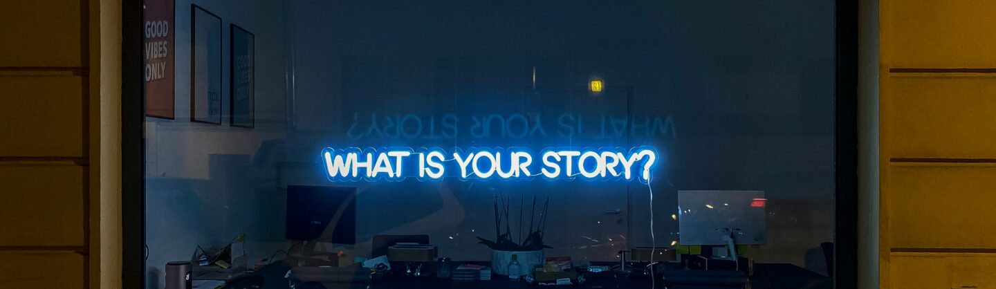 Neon sign that states What is your story