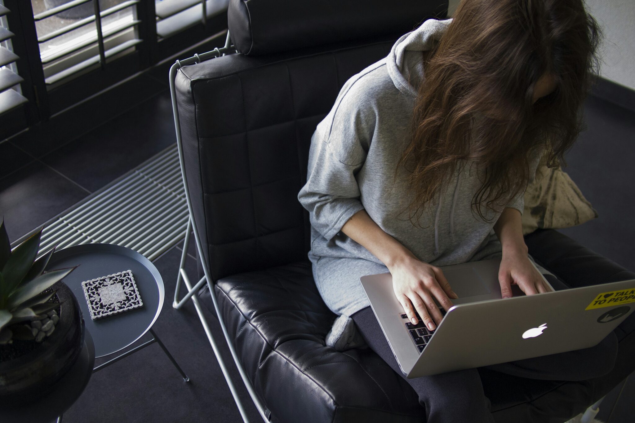 Young woman focused on her laptop, working in a productive and modern environment.