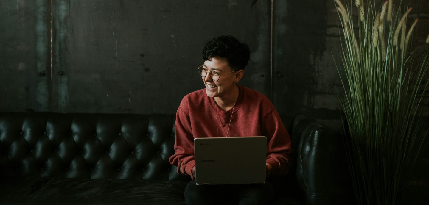 Young entrepreneur working on her laptop to build a website, promoting her services in a workspace.